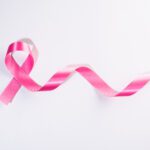 Pink ribbon cancer sign on white